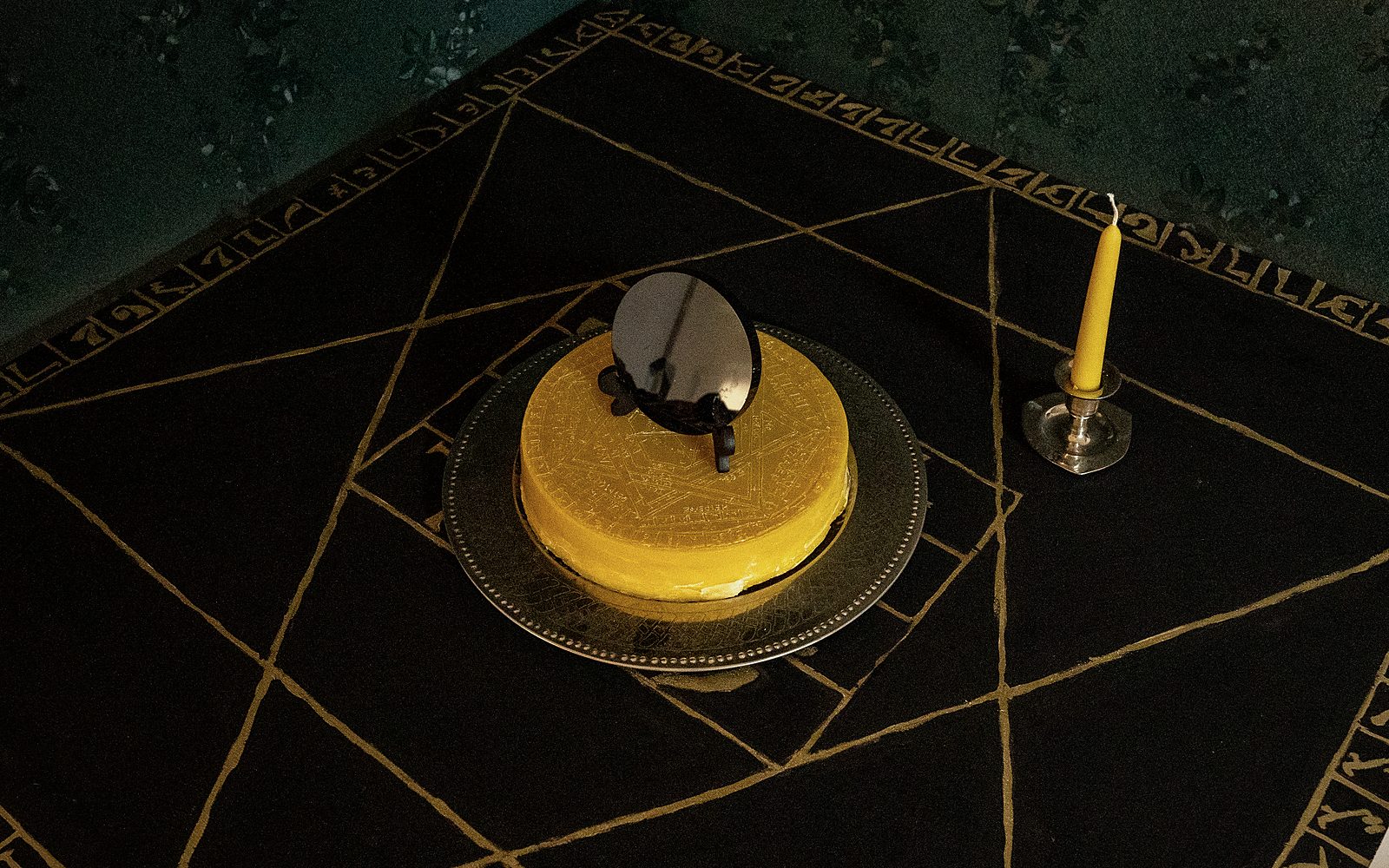 The Holy Table of Practice — gilded Enochian characters on its border, the wax Sigillum and the black scrying mirror at its centre